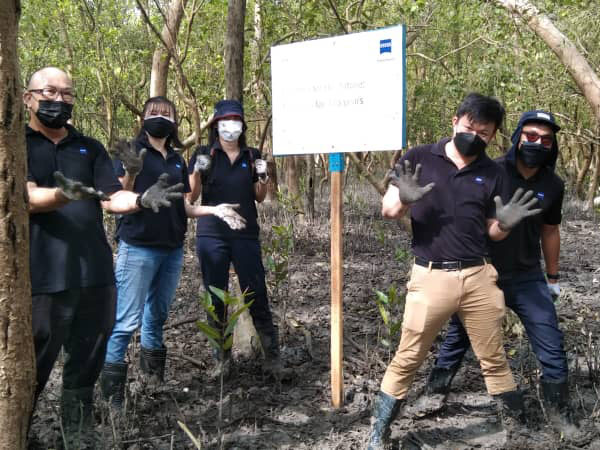 A group of 5 colleagues from ZEISS Southeast Asia standing around the sign