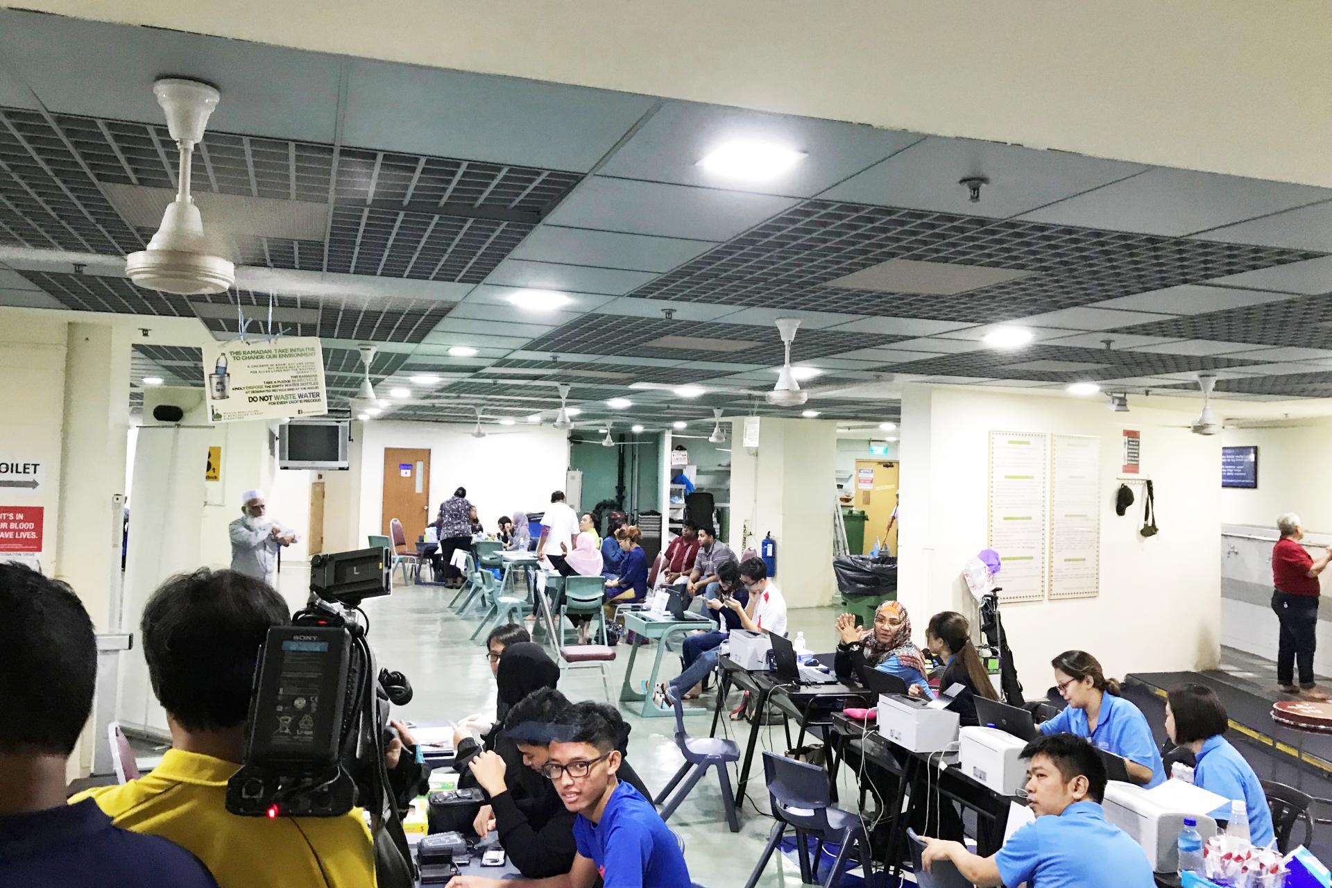 during Health Fair and Blood Donation Drive - a group of people sitting at desks in a room