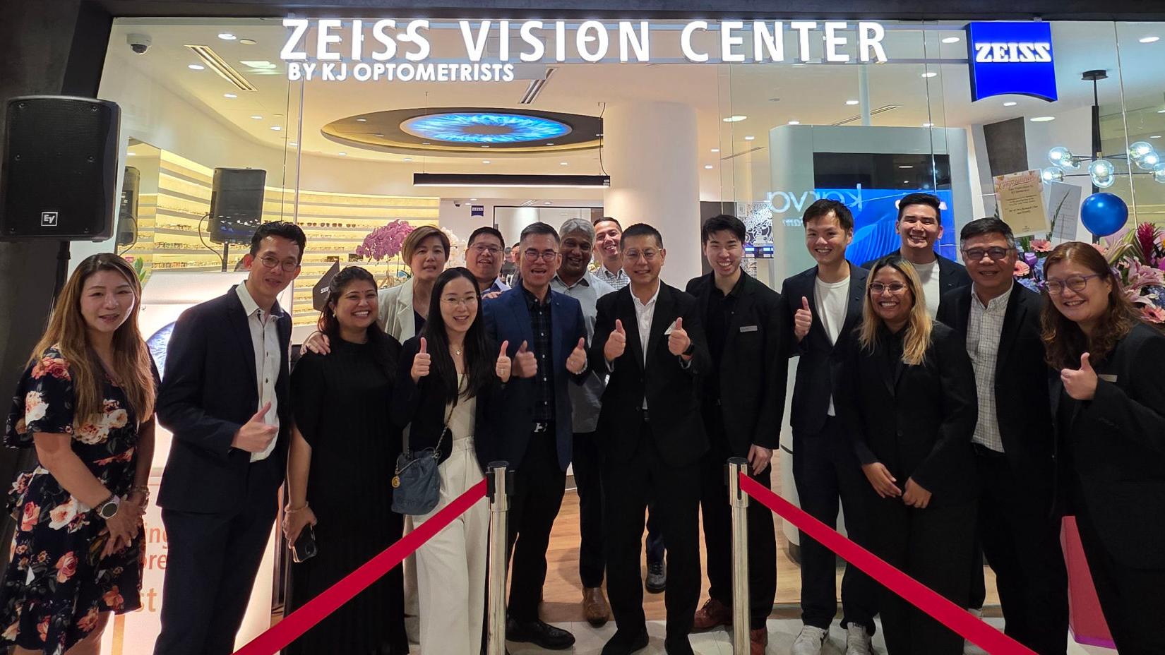 A group of people standing in front of the Zeiss Vision Center in Singapore