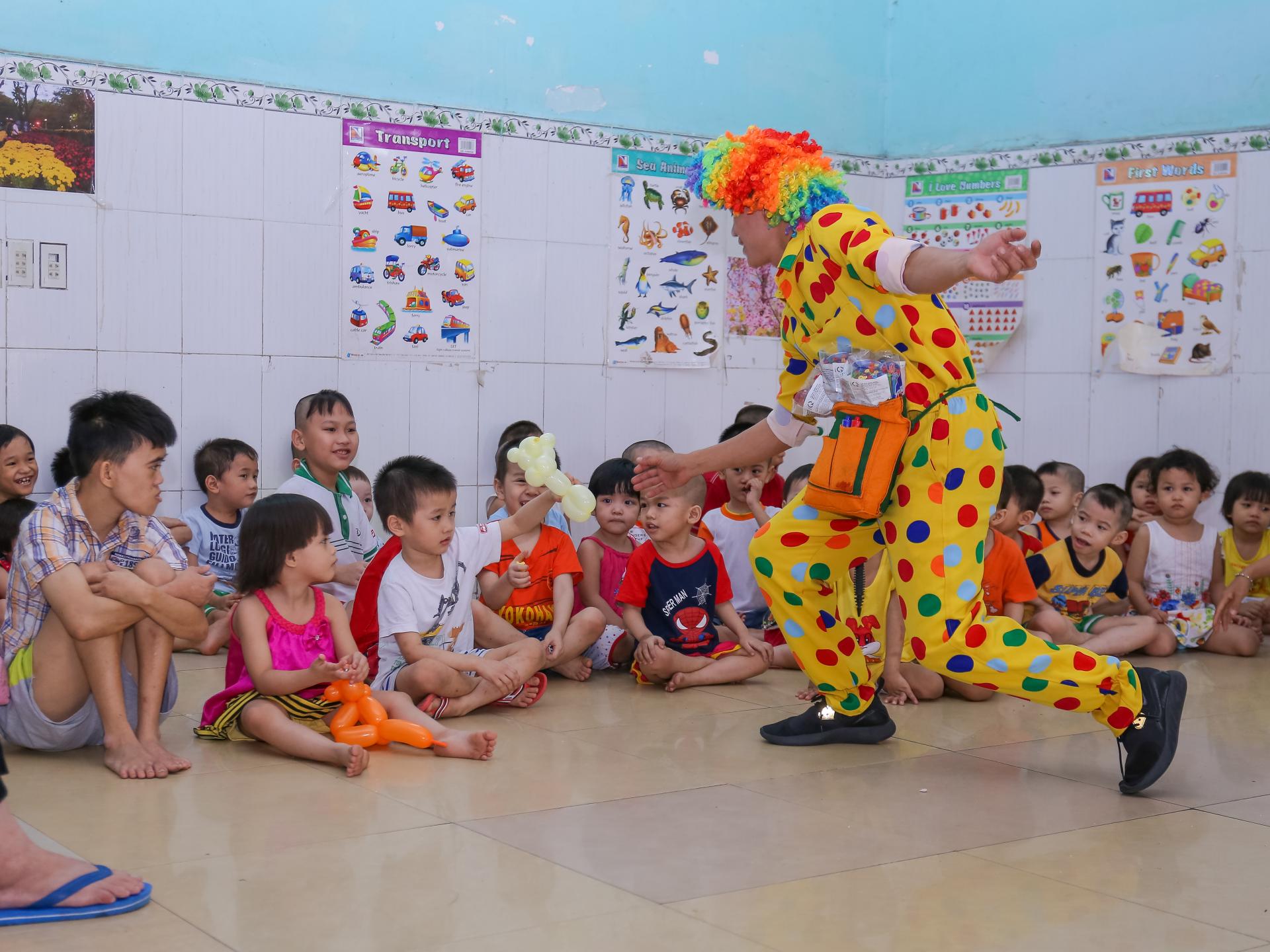 a clown is dancing in front of a group of children