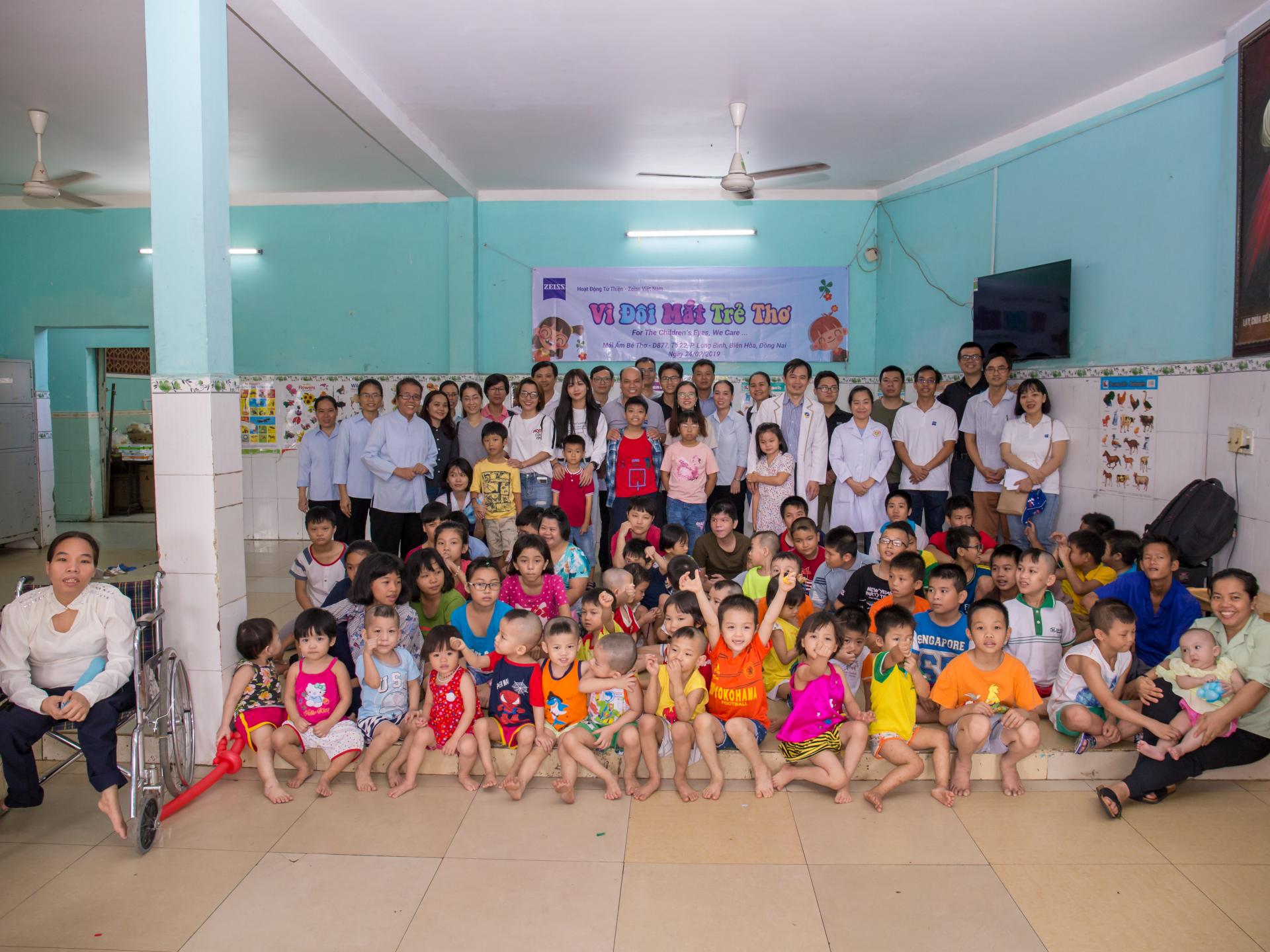 A collective picture of all participants of the ZEISS Vietnam corporate social responsibility event: in the foregroud are the children of Mai Am Be Tho, at the background are the doctors, the ZEISS Vietnam employees and the coworkers of Mai Am Be Tho