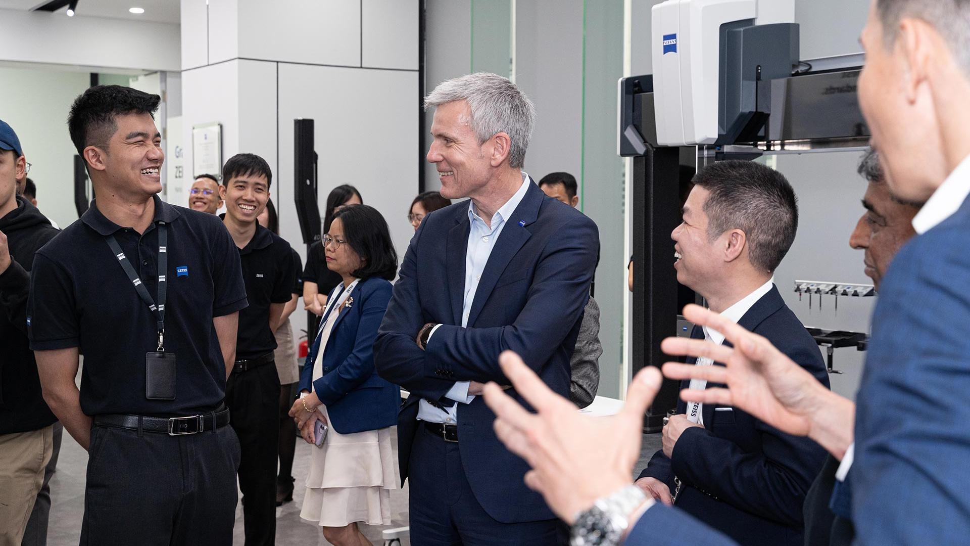Andreas Pecher speaks cheerfully with employees at the opening ceremony