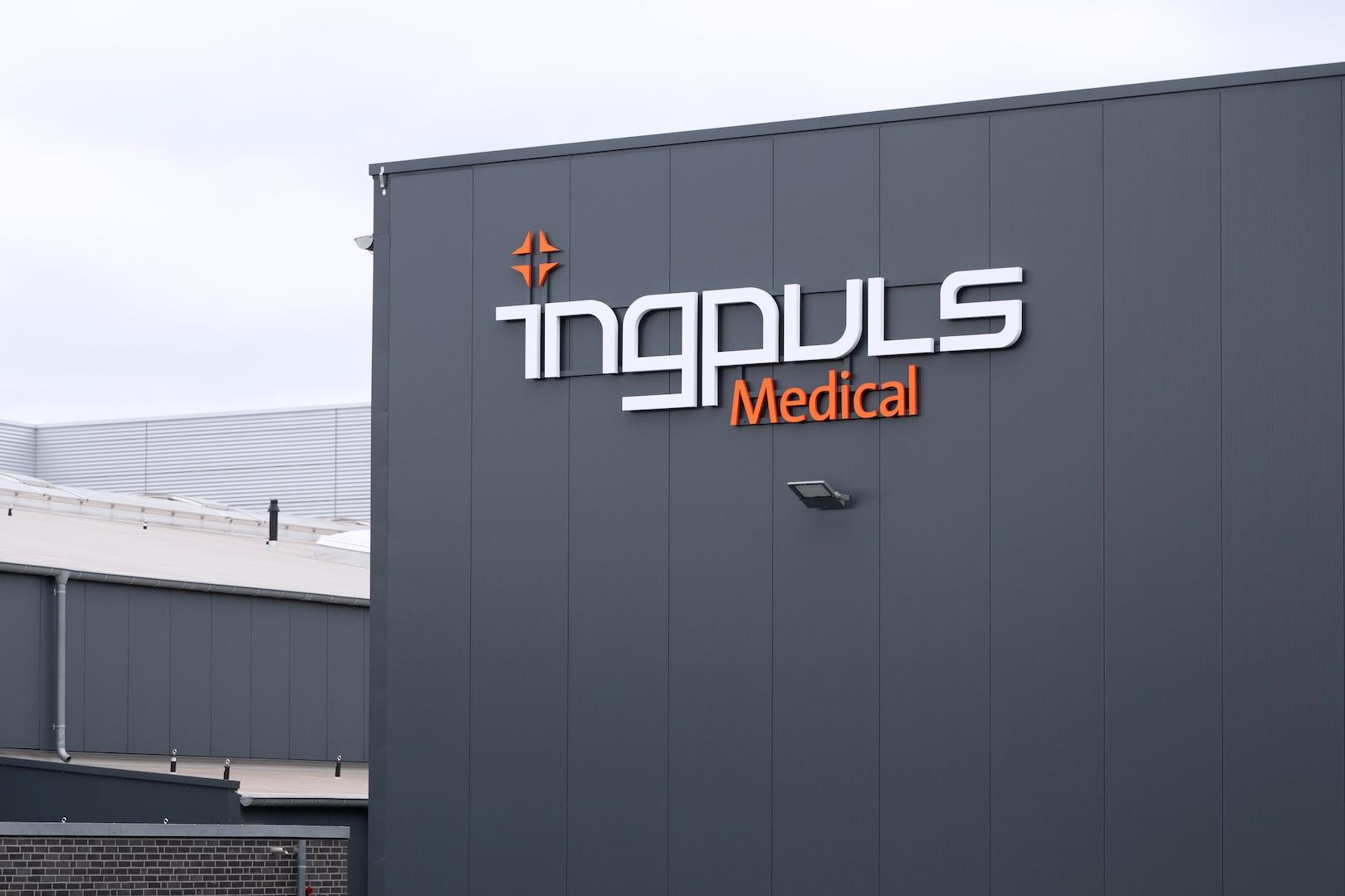 Exterior view of a modern industrial building with the logo "ingpuls Medical" displayed on the dark grey facade.