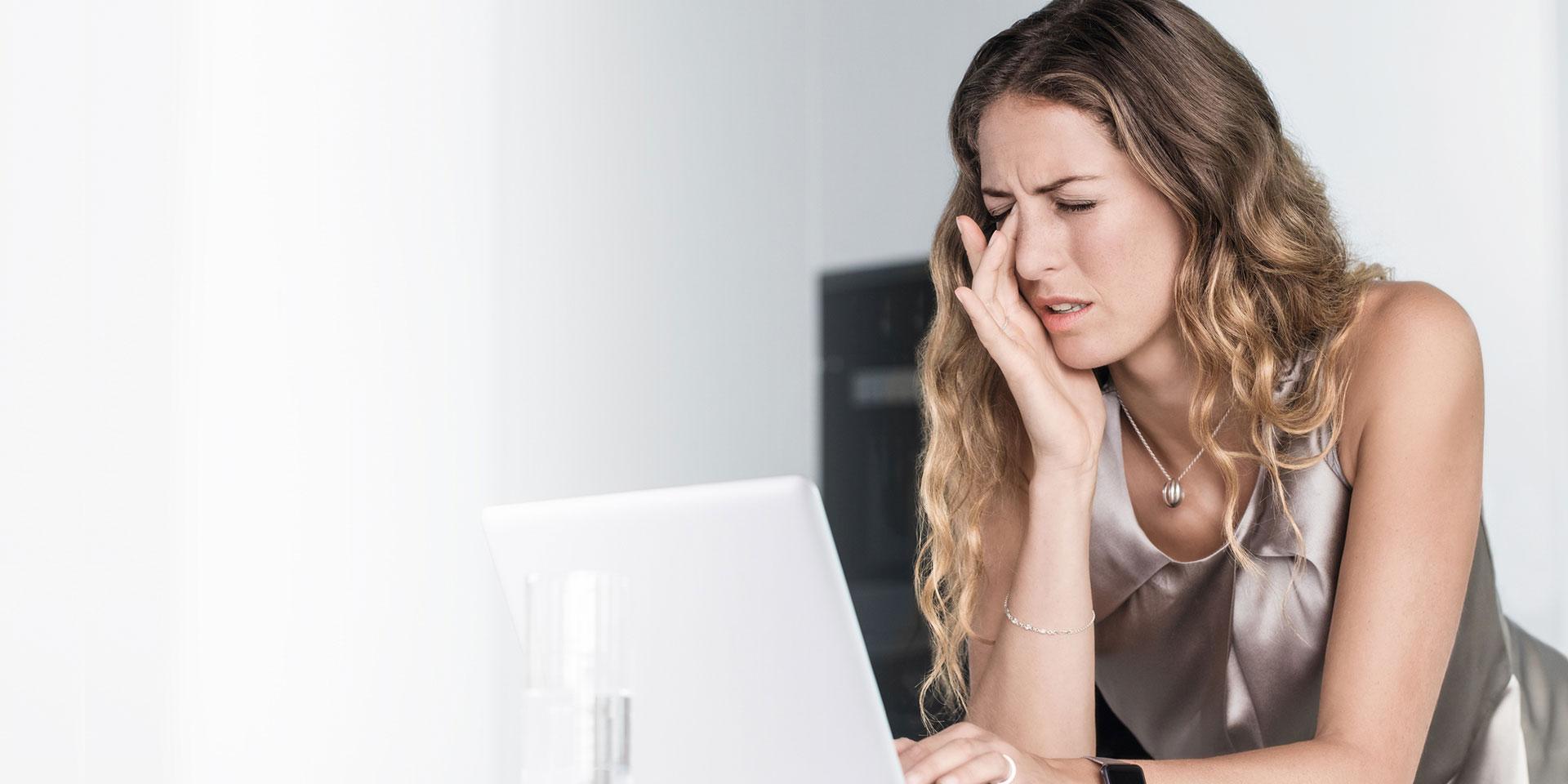 Woman looking at screen having eye strain