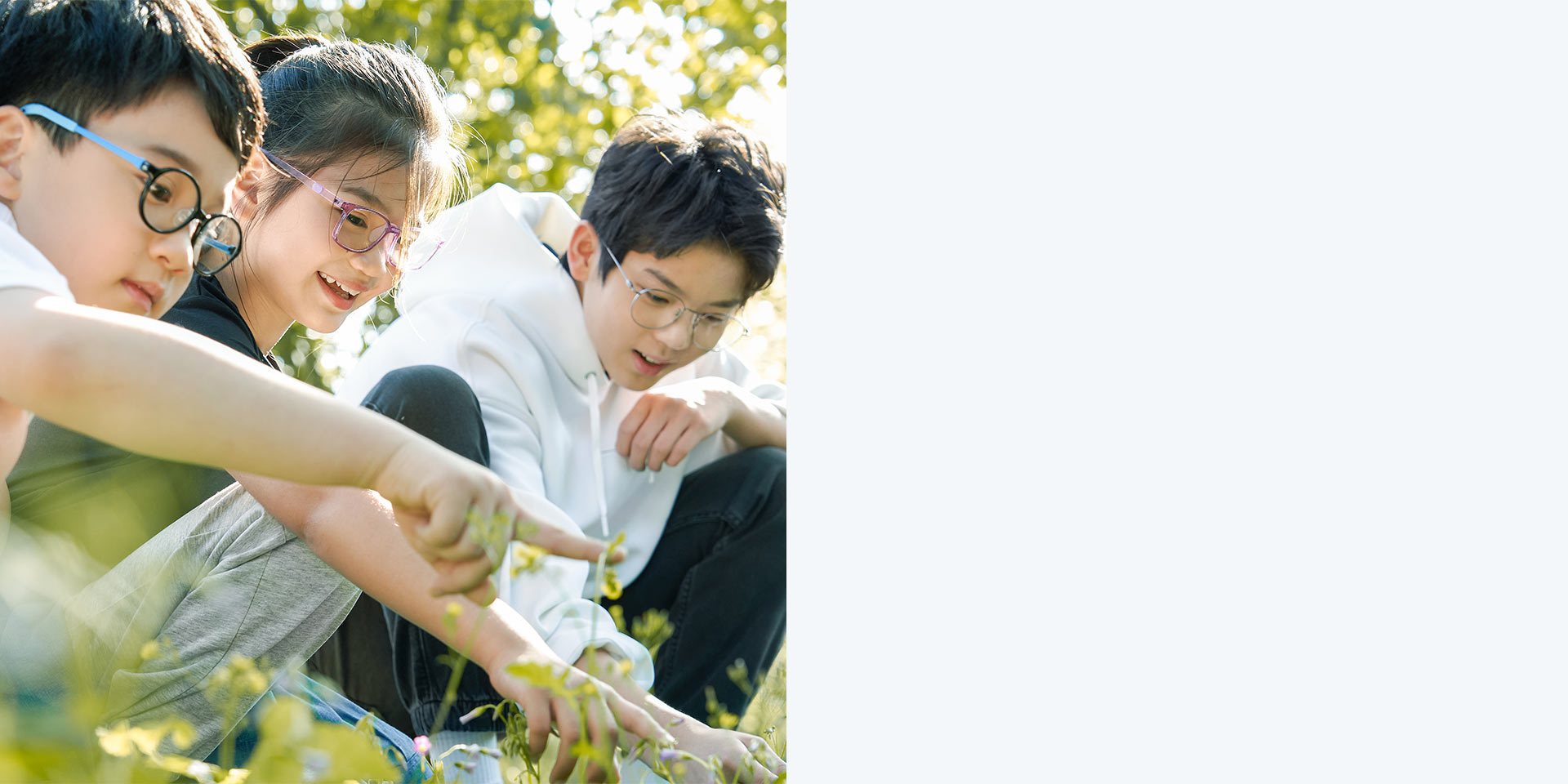 2 boys and 1 girl wearing ZEISS MyoCare lenses. They are looking and pointing at a plant.